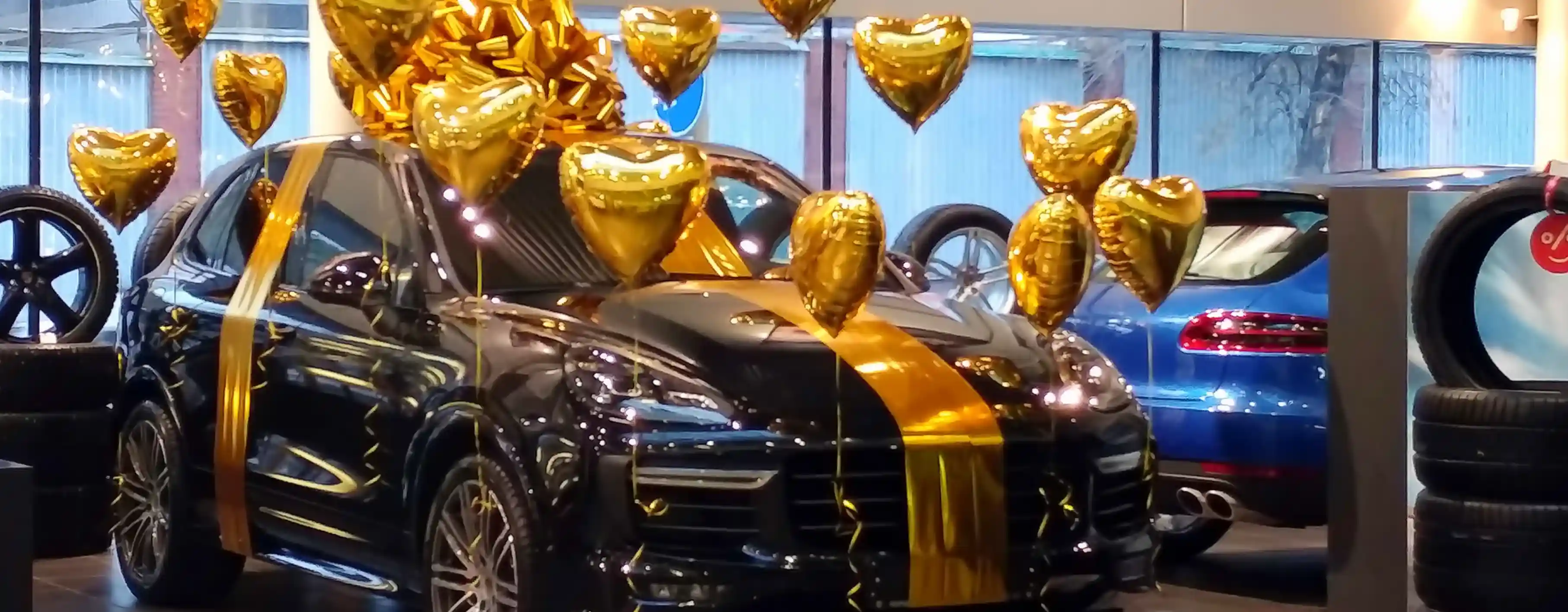 Colorful balloon displays at a car dealership attracting customers to a sales event