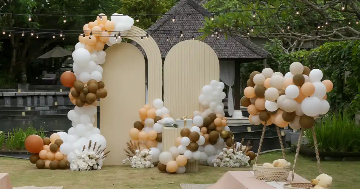 Elegant Sempertex balloon arch in white and champagne tones at a wedding venue